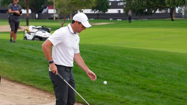 Rory McIlroy of Northern Ireland retrieves his ball from water on the 10th hole during the first round of the Dubai Desert Classic, in Dubai, United Arab Emirates, Thursday, Jan. 26, 2023. (AP Photo/Kamran Jebreili)