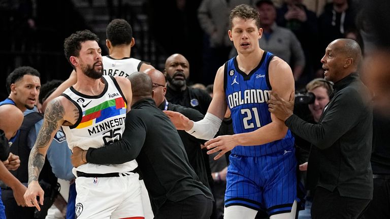 Minnesota Timberwolves guard Austin Rivers, middle, is held back after participating in a scrum with Orlando Magic players 