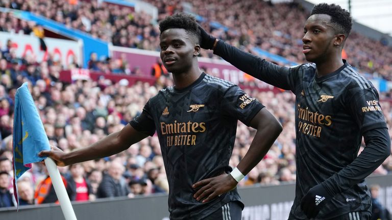 Arsenal's Bukayo Saka celebrates with Arsenal's Eddie Nketiah, right, after scoring his side's opening goal during the English Premier League soccer match between Aston Villa and Arsenal at Villa Park in Birmingham, England, Saturday, Feb. 18, 2023. (AP Photo/Jon Super)