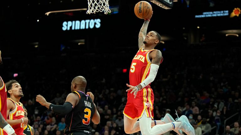 Atlanta Hawks guard Dejounte Murray dunks over Phoenix Suns guard Chris Paul