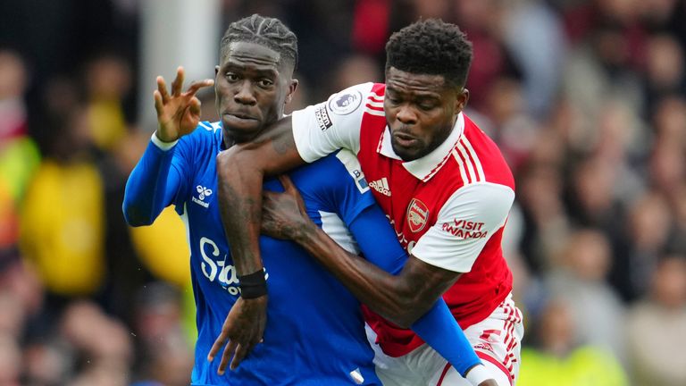 Amadou Onana shields the ball under pressure from Thomas Partey