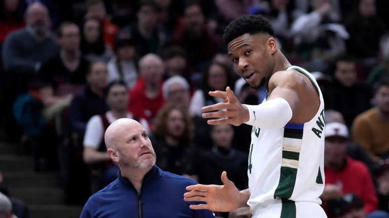 Milwaukee Bucks' Giannis Antetokounmpo points to where he injured his right wrist, while talking to a member of the medical staff as they head to the locker room during the first half of the team's NBA basketball 