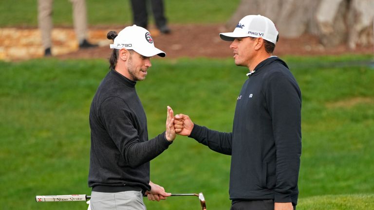 Gareth Bale, left, is greeted by Joseph Bramlett after putting on the third green of the Pebble Beach Golf Links during the third round of the AT&T Pebble Beach Pro-Am golf tournament in Pebble Beach, Calif., Saturday, Feb. 4, 2023. 