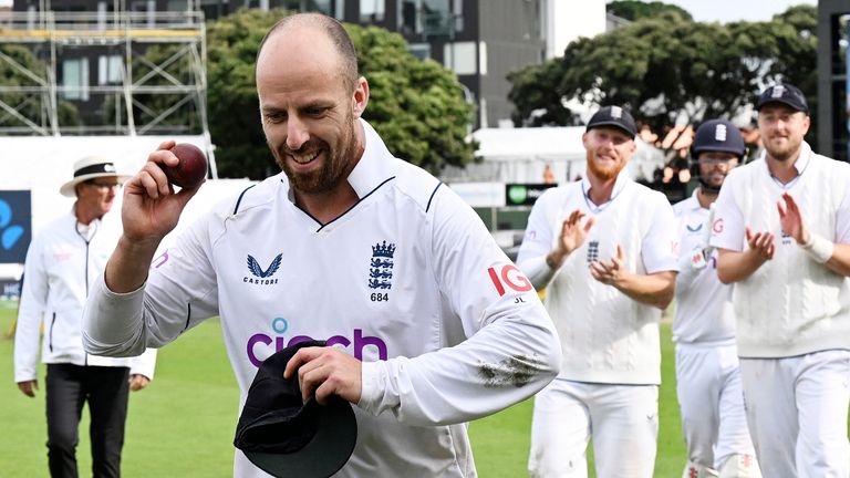 England's bowler Jack Leach holds the ball up as he leaves the field after taking 5 New Zealand wickets on day 4 of their cricket test match in Wellington, New Zealand, Monday, Feb 27, 2023. (Andrew Cornaga/Photosport via AP)