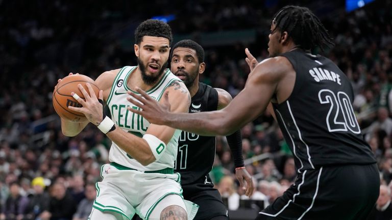 Boston Celtics forward Jayson Tatum is trapped between Brooklyn Nets center Day&#39;Ron Sharpe and guard Kyrie Irving