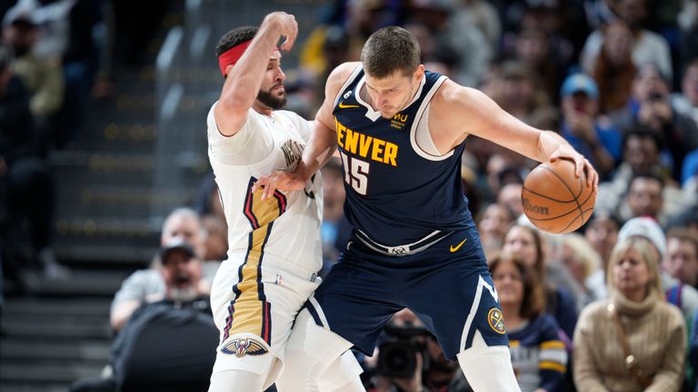 Denver Nuggets center Nikola Jokic, right, drives to the rim as New Orleans Pelicans forward Larry Nance Jr. in the second half of an NBA basketball game Tuesday, Jan. 31, 2023, in Denver.
