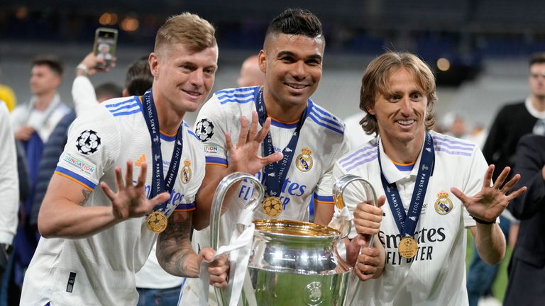 Real Madrid&#39;s Luka Modric, right, Real Madrid&#39;s Casemiro, center, and Real Madrid&#39;s Toni Kroos pose for a photograph with the trophy after winning the Champions League final soccer match between Liverpool and Real Madrid at the Stade de France in Saint Denis near Paris, Sunday, May 29, 2022. (AP Photo/Kirsty Wigglesworth)