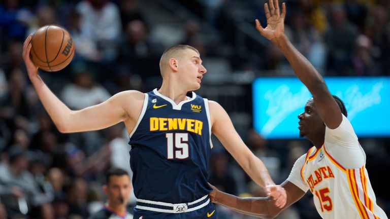 Denver Nuggets center Nikola Jokic, left, looks to pass the ball as Atlanta Hawks center Clint Capela defends in the first half of an NBA basketball game Saturday, Feb. 4, 2023, in Denver.