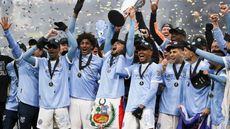 New York City FC players celebrate with the trophy after their penalty kick shootout win over the Portland Timbers in the MLS Cup soccer game, Saturday, Dec. 11, 2021, in Portland, Ore. (AP Photo/Amanda Loman)