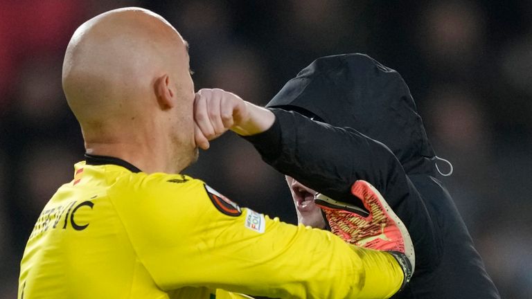 A PSV supporter punches Sevilla&#39;s goalkeeper Marko Dmitrovic in the face during the Europa League playoff second leg soccer match between PSV and Sevilla at the Philips stadium in Eindhoven, Netherlands, Thursday, Feb. 23, 2023. Sevilla won 3-2 on aggregate. (AP Photo/Peter Dejong)