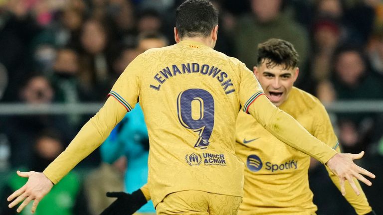 Barcelona&#39;s Robert Lewandowski, left, celebrates with his teammate Pedri after scoring his side&#39;s second goal during a Spanish La Liga soccer match between Real Betis and Barcelona at the Benito Villamarin stadium in Seville, Spain, Wednesday, Feb. 1, 2023. (AP Photo/Jose Breton)