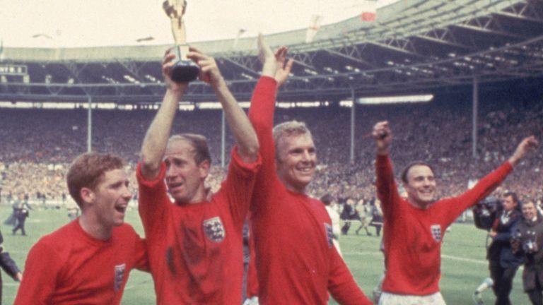 Bobby Charlton raises the Jules Rimet trophy in the air following England's 4-2 victory after extra time over West Germany in the World Cup Final at Wembley Stadium, 30th July 1966. Amongst his team mates celebrating with him are goalkeeper Gordon Banks, Alan Ball on his right and team captain Bobby Moore (1941 - 1993) at his left. (Photo by Hulton Archive/Getty Images)