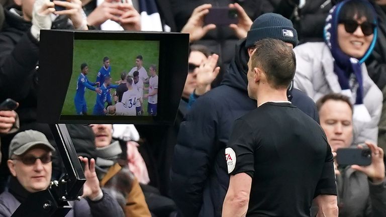 Referee Stuart Atwell looks the pitch-side VAR monitor before reversing his decision to give Hakim Ziyech a red card