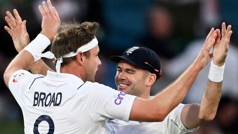 England's Stuart Broad, left, celebrates with teammates with teammate James Anderson after taking the wicket of New Zealand's Devon Conway on the third day of their cricket test match in Tauranga, New Zealand, Saturday, Feb. 18, 2023. (Andrew Cornaga/Photosport via AP)