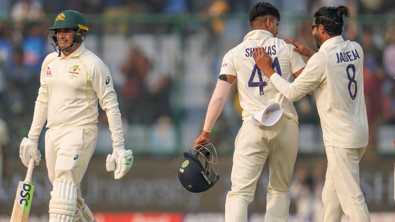 Australia's Usman Khawaja, left, walks off the pitch as Indian players celebrate his sacking during day two of the second Test cricket match between India and Australia in New Delhi, India on Saturday February 18 2023. (AP Photo/Altaf Qadri) 