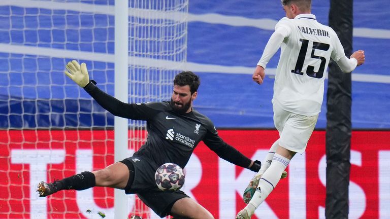 Real Madrid's Federico Valverde, right, tries to beat Liverpool's goalkeeper Alisson during the Champions League, round of 16 second leg soccer match between Real Madrid and Liverpool at the Santiago Bernabeu stadium in Wednesday, March 15, 2023. (AP Photo/Manu Fernandez)