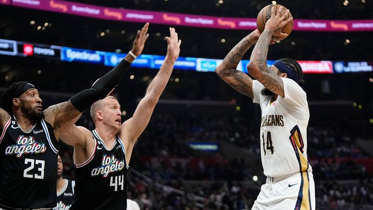 New Orleans Pelicans forward Brandon Ingram, right, shoots as Los Angeles Clippers forward Robert Covington, left, and center Mason Plumlee defend.