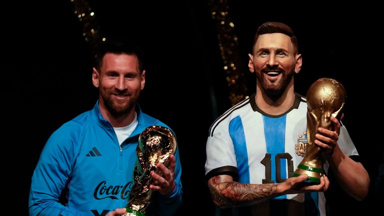 Argentina&#39;s soccer star Lionel Messi holds a replica of the FIFA World Cup trophy next to a statue of himself during a ceremony at the CONMEBOL headquarters in Asuncion, Monday, March 27, 2023. CONMEBOL authorities held a ceremony to honor the Argentine squad after they won the World Cup, prior to the draw for the group stage of Libertadores and Sudamericana tournaments. (AP Photo/Jorge Saenz)