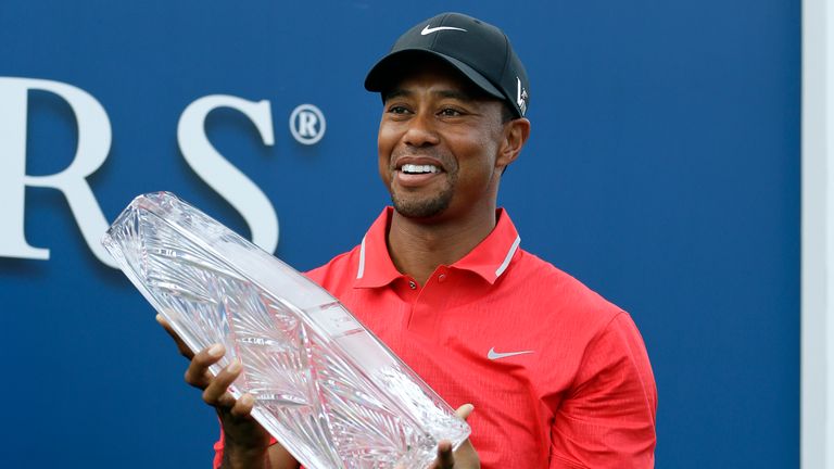 Tiger Woods smiles as he holds up the trophy after winning The Players Championship golf tournament at Sawgrass Sunday, May 12, 2013, in Ponte Vedra Beach, Fla.