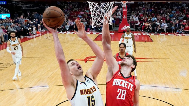 Denver Nuggets center Nikola Jokic (15) shoots as Houston Rockets center Alperen Sengun (28) defends.