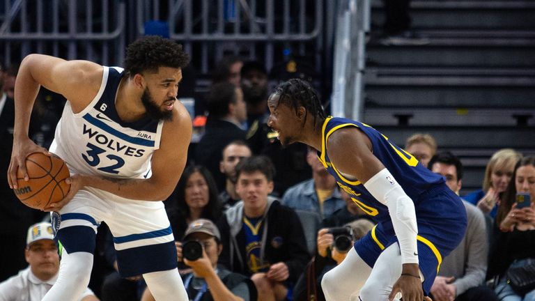 Minnesota Timberwolves forward Karl-Anthony Towns (32) looks to drive around Golden State Warriors forward Jonathan Kuminga (00).