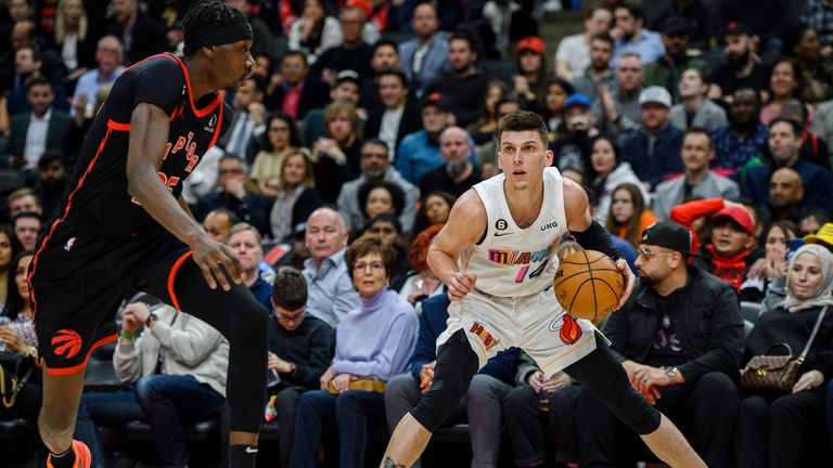 Miami Heat guard Tyler Herro looks to the net while defended by Toronto Raptors forward Chris Boucher.