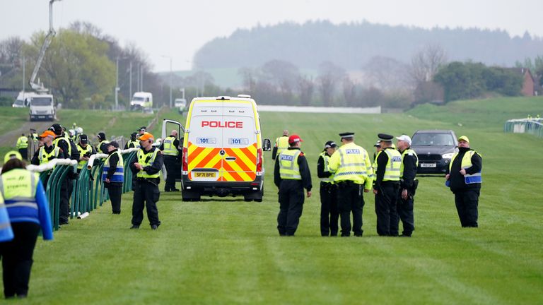 Police and security clear the track at Ayr after protestors targeted the Scottish Grand National meeting