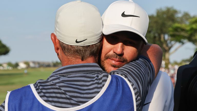 Captain Brooks Koepka of Smash GC hugs his caddie after winning the individual championship after the final round of LIV Golf Orlando at Orange County National on Sunday, Apr. 02, 2023 in Winter Garden, Florida. (Photo by Jon Ferrey/LIV Golf via AP)