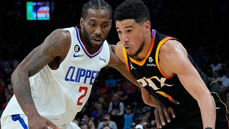 Phoenix Suns guard Devin Booker (1) drives on Los Angeles Clippers forward Kawhi Leonard (2) during the second half of Game 2 of a first-round NBA basketball playoff series, Tuesday, April 18, 2023, in Phoenix. (AP Photo/Matt York)