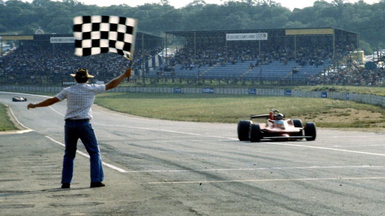 Gilles Villeneuve, Ferrari 312T4, takes the chequered flag and celebrates.