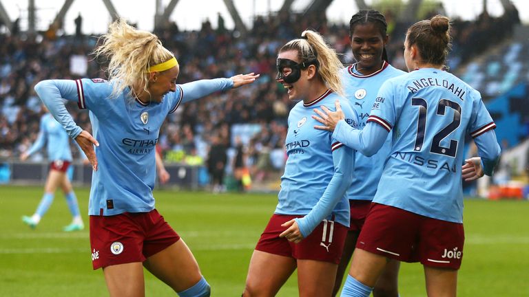 Lauren Hemp is bombarded by team-mates after scoring City's third