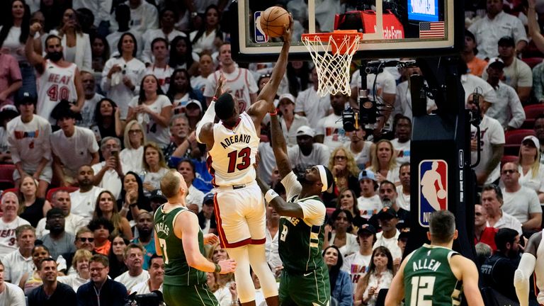Miami Heat center Bam Adebayo goes to the basket as Milwaukee Bucks guard Joe Ingles  and forwards Bobby Portis defend 