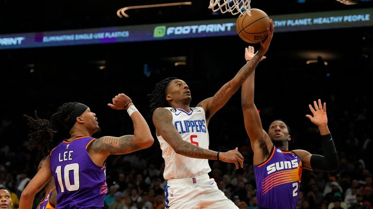Los Angeles Clippers guard Bones Hyland (5) drives between Phoenix Suns guard Damion Lee and Phoenix Suns forward Josh Okogie (2) during the second half of an NBA basketball game, Sunday, April 9, 2023, in Phoenix. The Clippers won 119-114. (AP Photo/Rick Scuteri)