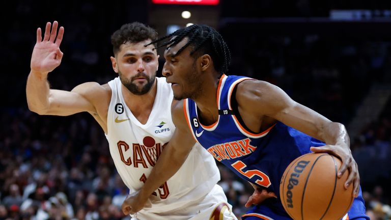 New York Knicks guard Immanuel Quickley (5) drives against Cleveland Cavaliers guard Raul Neto, left, during the second half of an NBA basketball game, Friday, March 31, 2023, in Cleveland. (AP Photo/Ron Schwane)


