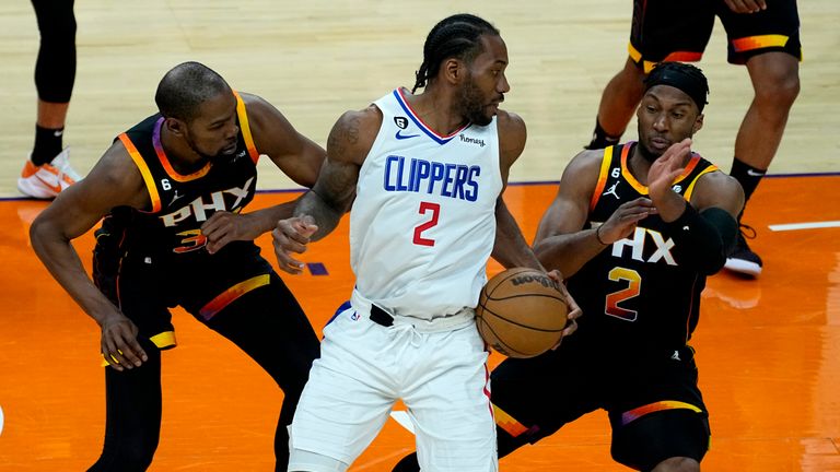 Los Angeles Clippers forward Kawhi Leonard (2) looks to pass under pressure from Phoenix Suns forward Josh Okogie (2) and forward Kevin Durant during the second half of Game 2 of a first-round NBA basketball playoff series, Tuesday, April 18, 2023, in Phoenix. (AP Photo/Matt York)