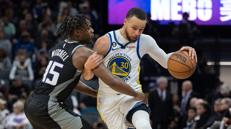 Sacramento Kings guard Davion Mitchell (15) fouls Golden State Warriors guard Stephen Curry (30) during the second half in an NBA basketball game in Sacramento, Calif., Friday, April 7, 2023. The Warriors won 119-97.