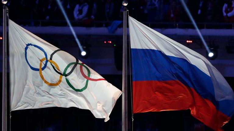 FILE - The Russian national flag, right, flies after it is hoisted next to the Olympic flag during the closing ceremony of the 2014 Winter Olympics in Sochi, Russia, Feb. 23, 2014. Track and field leaders signaled Thursday, March 23, 2023, that it will be nearly impossible for Russian and Belarusian athletes to compete at the Paris Olympics next year if the war in Ukraine continues. (AP Photo/Matthias Schrader, File) 