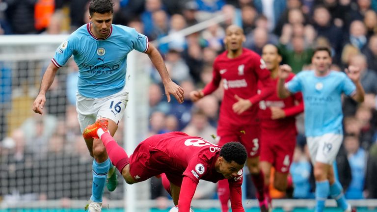 Liverpool's Cody Gakpo falls while fighting for a ball with Manchester City's Rodrigo during the English Premier League soccer match between Manchester City and Liverpool at Etihad stadium in Manchester, England, Saturday, April 1, 2023. (AP Photo/Jon Super)