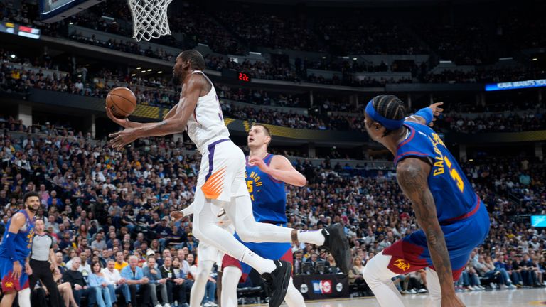 Phoenix Suns forward Kevin Durant, front left, drives to the basket as Denver Nuggets center Nikola Jokic, back left, and guard Kentavious Caldwell-Pope, right, defend in the second half of Game 1 of an NBA second-round basketball series Saturday, April 29, 2023, in Denver.