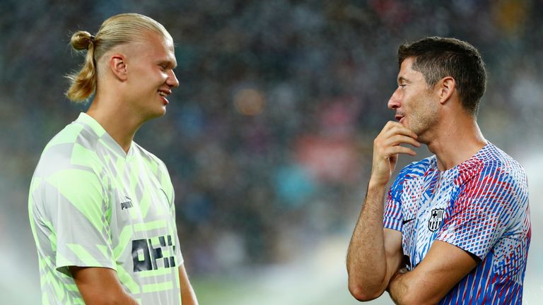 Manchester City's Erling Haaland, left, speaks with Barcelona's Robert Lewandowski ahead of a charity friendly soccer match between Barcelona and Manchester City at the Camp Nou stadium in Barcelona, Spain, Wednesday, Aug. 24, 2022. (AP Photo/Joan Monfort)