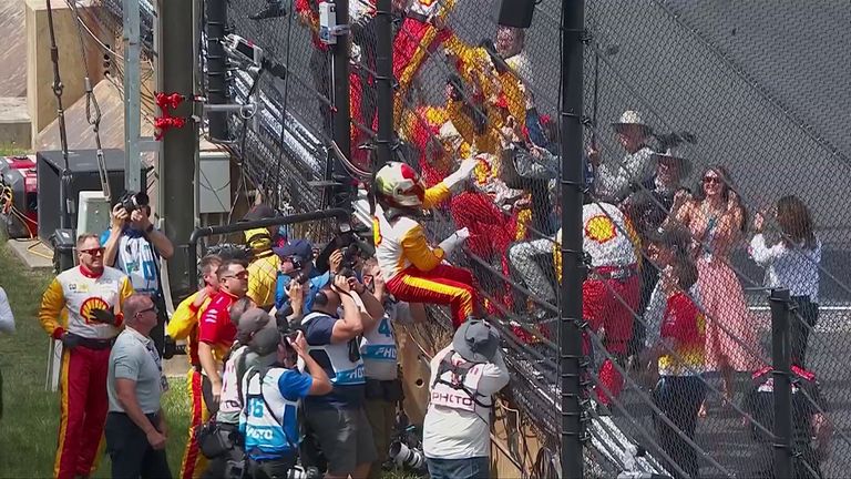 Newgarden celebrates his Indy 500 win by running into the crowd.