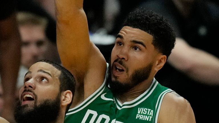 Miami Heat forward Caleb Martin (16) drives to the basket as Boston Celtics forward Jayson Tatum (0) defends during the first half of Game 4 of the NBA basketball playoffs Eastern Conference finals, Tuesday, May 23, 2023, in Miami. (AP Photo/Rebecca Blackwell)