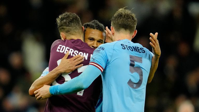 Manchester City&#39;s goalkeeper Ederson, left, celebrates with his teammates John Stones, right, and Nathan Ake at the end of the Champions League quarterfinal, first leg, soccer match between Manchester City and Bayern Munich at the Etihad stadium in Manchester, England, Tuesday, April 11, 2023. Manchester City won 3-0. (AP Photo/Jon Super)