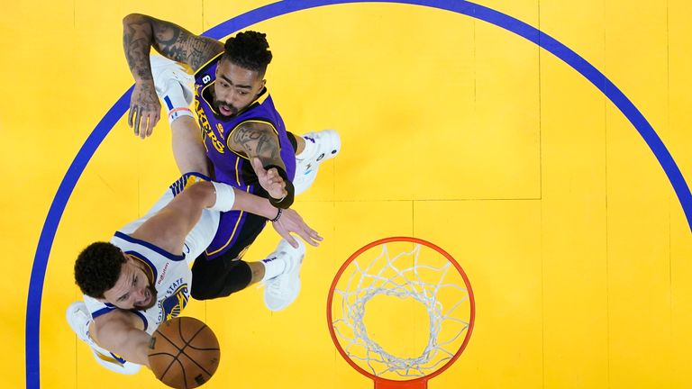Golden State Warriors guard Klay Thompson, left, shoots while defended by Los Angeles Lakers guard D'Angelo Russell.