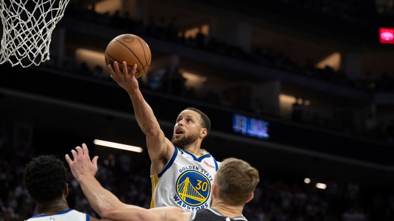 Golden State Warriors guard Stephen Curry (30) scores between Warriors forward Andrew Wiggins, left, and Sacramento Kings forward Domantas Sabonis.
