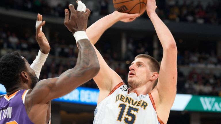 Denver Nuggets center Nikola Jokic, right, goes up for a basket over Phoenix Suns center Deandre Ayton in the first half of Game 5 of an NBA basketball Western Conference semifinal series Tuesday, May 9, 2023, in Denver. (AP Photo/David Zalubowski)