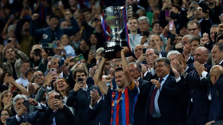 Barcelona's team captain Sergio Busquets lifts the championship trophy at the end of a Spanish La Liga soccer match between Barcelona and Real Sociedad at Camp Nou stadium in Barcelona, Spain, Saturday, May 20, 2023. Barcelona clinched the Spanish league title last Sunday with four rounds still to be played.(AP Photo/Joan Monfort)