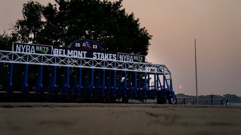 A starting gate rests unused on an empty track as haze from Canadian wildfires obscures the sun ahead of the Belmont Stakes