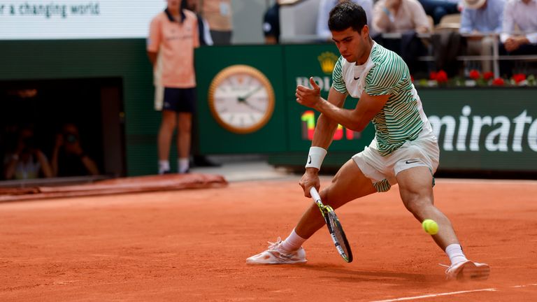 Spain&#39;s Carlos Alcaraz plays a shot and score with his back to Serbia&#39;s Novak Djokovic in the third game of the second set of their semifinal match of the French Open tennis tournament of the French Open tennis tournament at the Roland Garros stadium in Paris, Friday, June 9, 2023. (AP Photo/Jean-Francois Badias)
