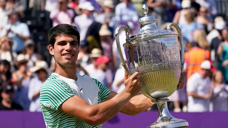 Carlos Alcaraz, of Spain, holds the trophy after defeating Alex de Minaur, of Australia, 6/4, 6/4 in the mens singles final match at the Queens Club tennis tournament in London, Sunday, June 25, 2023. (AP Photo/Alberto Pezzali)